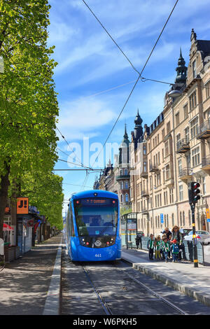Storstockholms Lokaltrafik SL ou tramway bleu et les passagers en attente à un arrêt à STHLM (Östermalmstorg). Réseau de transport public suédois. Banque D'Images