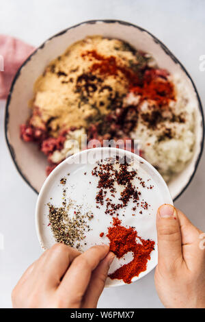 Saupoudrer d'épices Turkish kofta ingrédients dans un bol en céramique Banque D'Images