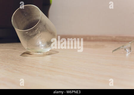 Verre à vin cassé sur un plancher en bois. Banque D'Images