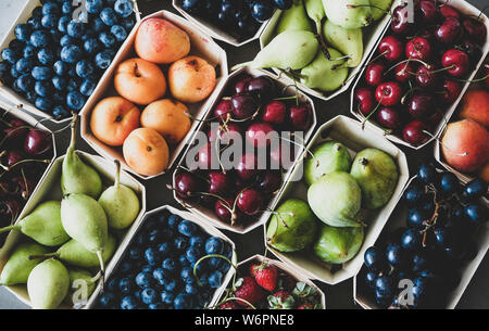 Fruits et baies diverses. Télévision à jeter des fraises mûres, bleuets, cerises, raisins, poires, abricots, figues dans des boîtes en bois plus respectueux de l'environnement Banque D'Images