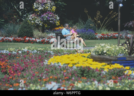 Un couple lecture à Beach House Park, Worthing, West Sussex, England, UK Banque D'Images