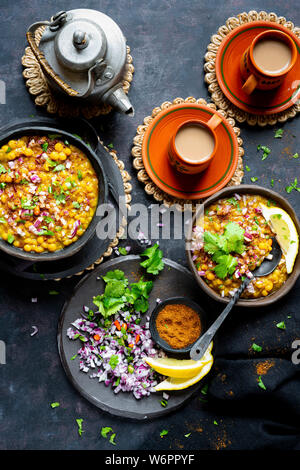 Curry de lentilles vegan indien servi avec de l'oignon haché, la coriandre, Les chiles verts , de la terre fraîche et d'épices chai fraîchement préparés. Banque D'Images