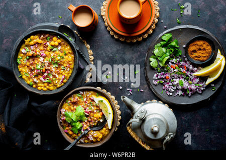 Curry de lentilles vegan indien servi avec de l'oignon haché, la coriandre, Les chiles verts , de la terre fraîche et d'épices chai fraîchement préparés. Banque D'Images