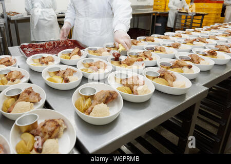 Chef, c'est Répartition alimentaire à bord - L'ajout de sauce plat de poulet grillé, réalité tourné Banque D'Images