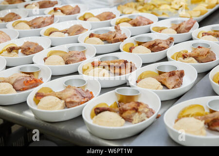 La cuisson à bord en cuisine professionnelle - des cuisses de poulet avec sauce aux baies et purée Banque D'Images