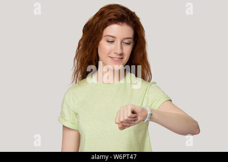 Femme à tête rouge à la montre-bracelet à se sent convaincu studio portrait Banque D'Images