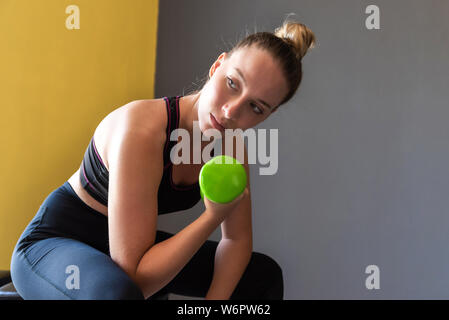 Fille de remise en forme d'haltère de levage dans la salle de sport. Banque D'Images