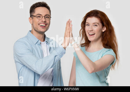 Studio shot heureux couple millénaire haute donnant cinq mains geste Banque D'Images