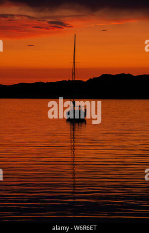 Coucher du soleil au large Sheildaig sur la côte ouest de l'Ecosse avec un seul la location ou en eau calme, près de la côte. Banque D'Images