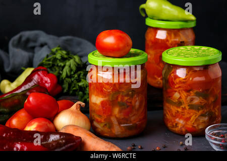 Salade de légumes en bocaux pour l'hiver de tomates, carottes, oignons et poivrons, entente horizontale Banque D'Images