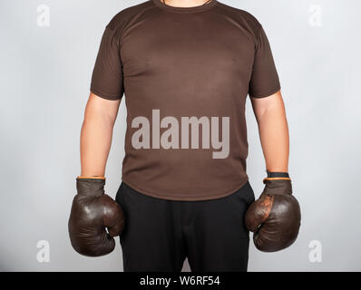 Jeune homme se tient en tenue très old vintage brown des gants de boxe sur ses mains, fond blanc Banque D'Images