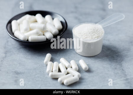 Poudre de collagène, Proline et MSM (soufre) capsules. Compléments alimentaires pour soutenir la production de collagène. Pierre lumineuse arrière-plan. Close up. Banque D'Images