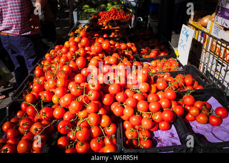 Tomates fraîches rouge vif sur un légumes dans le dynamique marché hebdomadaire le vendredi à Oliva en Espagne Banque D'Images