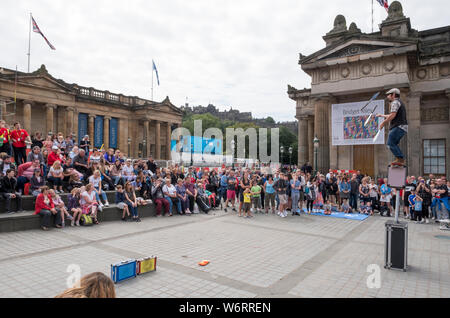 Un artiste de rue divertit la foule sur le Mound à Édimbourg, partie du Festival Fringe d'Édimbourg, le plus grand festival d'art au monde. Banque D'Images