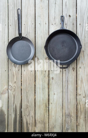 Cuisine traditionnelle vs nouvelle bataille - fontes par rapport à l'acier au carbone ou en téflon. Fond de bois. Ustensile de cuisine plus saine des options. R texte vide vide Banque D'Images