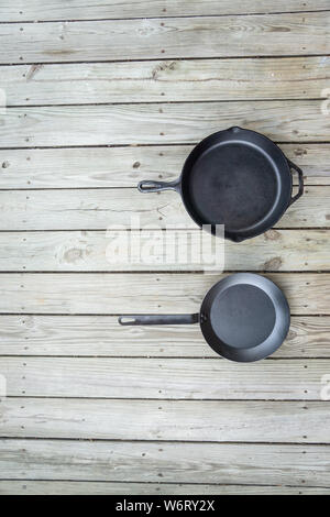 Fonte d'acier au carbone vs vs casseroles en téflon. Poêle de cuisine bataille pour comparaison options de cuisson plus saine de cuisinière à four à feu de camp. Vide Vide Banque D'Images