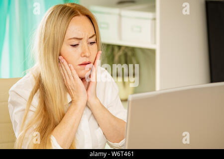 A souligné en colère young business woman utiliser laptop faisant tâche difficile souffrent de maux de tête au travail un sentiment de fatigue ou d'ennui, frustrés de employé épuisé Banque D'Images