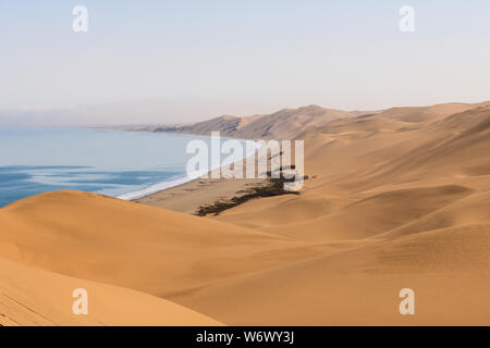 Le paysage spectaculaire donné par les dunes qui répondent à l'océan dans la baie de Sandwich, la Namibie. Banque D'Images