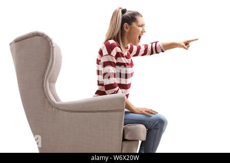 Femme en colère dans un fauteuil en criant isolé sur fond blanc Banque D'Images