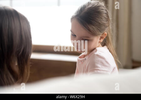 L'accent sur sad little daughter sitting on couch with mother Banque D'Images