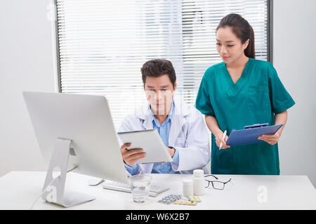 Groupe de médecins et d'infirmières l'examen rapport médical du patient. Équipe de médecins qui travaillent ensemble sur les patients à l'hôpital de fichier. Banque D'Images