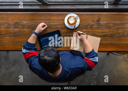 High angle view of Asian investor contrôle de stock market sur tablette Banque D'Images