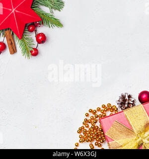 Fond d'écran de Noël. Étoile rouge, vert sapin, cadeaux de Noël, des baies de houx rouge babioles et sur plâtre stuc blanc texture. Composition de Noël, haut Banque D'Images