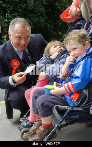 Acteur Rik Mayall sur walkabout de caractère comme MP Alan B'Stard, la promotion de la production de théâtre de tournée de "The New Statesman" dont il a été en vedette dans au Malvern Theatres. Church Street, Great Malvern, Worcestershire. Alan B'Stard MP offrir aux enfants de l'argent. Le 15/05/2007 Banque D'Images