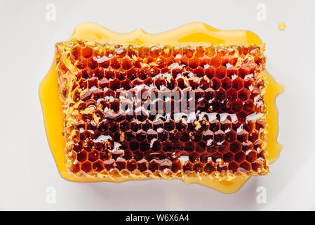 Vue de dessus du délicieux miel délicieux sur la plaque lumineuse de l'éclairage de fond en bois Banque D'Images