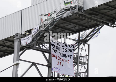 Mannheim, Allemagne. 3 août 2019. Une grande banderole vole depuis les territoires occupés de la bande de charbon, lire '20 ans vos bénéfices au lieu de notre avenir - Sortir de l'énergie charbon maintenant'. Des militants de l'Ende Gelande organisation ont occupé la courroie du convoyeur de charbon sur la grande centrale de charbon à Mannheim. Ils bloquent l'entrée principale de l'usine, appelant à la fin de l'utilisation du charbon dans la production d'énergie et l'utilisation de sources d'énergie renouvelables. Banque D'Images