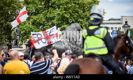 Londres, Royaume-Uni. 3 août 2019. Une manifestation de partisans de Stephen Yaxley-Lennon, connu sous le nom de Tommy Robinson, récemment emprisonné après avoir été reconnu coupable d'outrage au tribunal, passe par Trafalgar Square, en même temps que des milliers de membres du public de prendre part à la Prudential RideLondon événement Freecycle. Crédit : Stephen Chung / Alamy Live News Banque D'Images