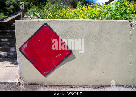 Blank red sign sur barrière de béton sur journée ensoleillée en milieu urbain Banque D'Images