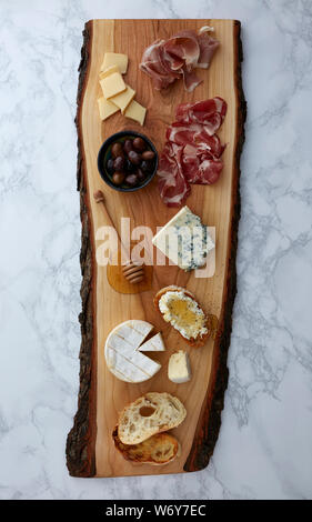 Assortiment de charcuterie sur une planche à découper en bois rustique sur une surface en marbre Banque D'Images