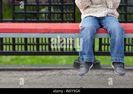 Enfant les jambes pendantes de la paillasse Banque D'Images