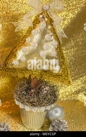 L'arbre de Noël fait main, type coussin orné de pierres, et bow dentelle avec des tons d'or et d'argent, pour la table ou la décoration de la maison Banque D'Images