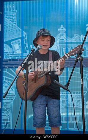 Royal Mile, stade Mercat, Édimbourg, Écosse, Royaume-Uni. 3 août 2019. Edinburgh Fringe, un certain 12 ans Stuart Veitch d'Aberdeen effectue chant et guitare électrique à un public. Banque D'Images