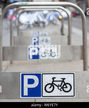 Parking pour vélo avec panneaux dans un centre-ville animé Banque D'Images