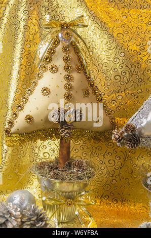 L'arbre de Noël fait main, type coussin orné de pierres, et bow dentelle avec des tons d'or et d'argent, pour la table ou la décoration de la maison Banque D'Images