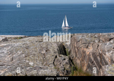 Ursholmen, Suède - Juillet 26, 2019 : Avis d'un voilier au large de l'île de Ursholmen dans le Parc National de Kosterhavet suédois dans l'ouest de la Suède. Banque D'Images