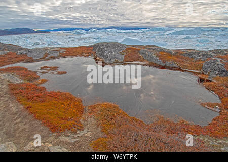 Étang gelé, réflexions, et la glace à l'automne dans l'Arctique par le Fjord glacé d'Ilulissat, Groenland. Banque D'Images