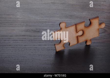 Deux pièces de bois de puzzle sur fond de bois Banque D'Images