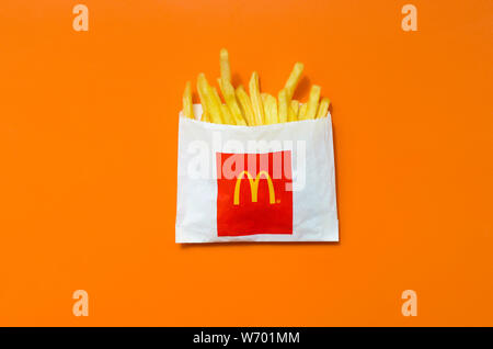 KHARKIV, UKRAINE - 1 août 2019 : McDonald's les frites dans de petits the paperbag sur fond orange vif. McDonald's Corporation est le grands Banque D'Images