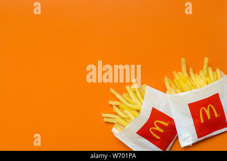 KHARKIV, UKRAINE - 1 août 2019 : McDonald's les frites dans de petits the paperbag sur fond orange vif. McDonald's Corporation est le grands Banque D'Images