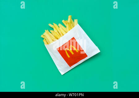 KHARKIV, UKRAINE - 1 août 2019 : McDonald's les frites dans de petits the paperbag sur fond vert vif. McDonald's Corporation est la plus grande organisation mondiale de Banque D'Images