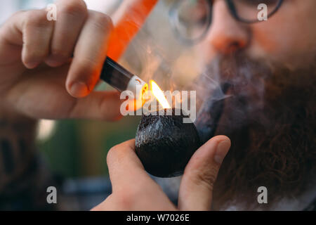 Portrait de l'homme assis et fumer pipe. Banque D'Images