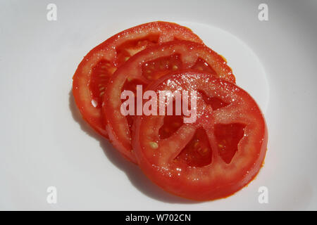 Des tranches de tomate. Anneaux de tomate. Les tranches de tomate. Tranches de tomates fraîches en rondelles. Banque D'Images