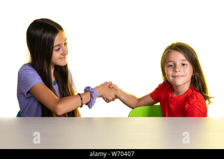 Deux jeunes filles donner handshake isolated on white, du concept d'équipe réussi ou féliciter les uns les autres. Banque D'Images