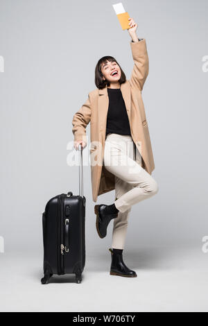 Happy young woman holding suitcase, touristiques et de passeport, billets, isolé sur fond blanc Banque D'Images