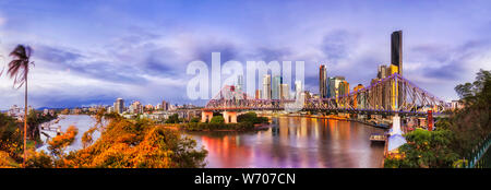 Sunrise panorama de ville Brisbane CBD landmarks et hautes tours derrière Histoire pont sur la rivière de Brisbane avec feux lumineux reflétant dans Banque D'Images