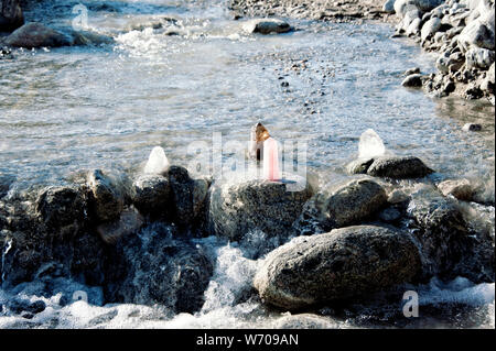 Cristal de Quartz Rose et d'autres cristaux sur une pierre dans la rivière d'être nettoyés par l'énergie du soleil et l'écoulement de l'eau. Still Life la photographie. Banque D'Images